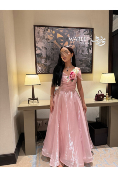 WAREEF FASHION A shimmering pink off-the-shoulder evening dress with a side f...