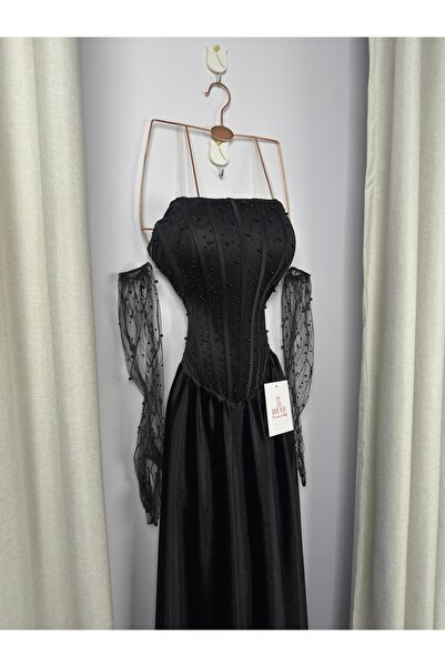 Riva An elegant black dress, with a corset cut and sheer lace sleeves.