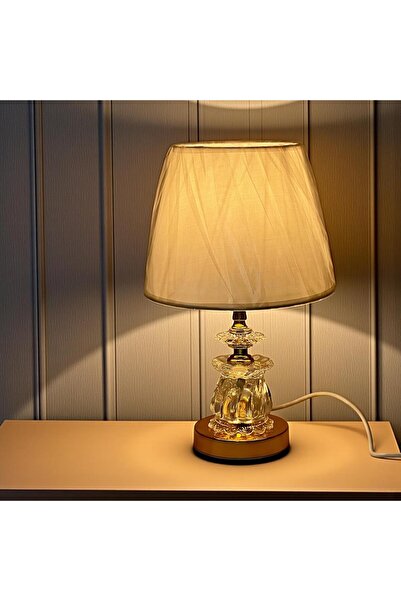 Gharaib Al Tuhaf An elegant glass table lamp with warm lighting and a touch of luxury.