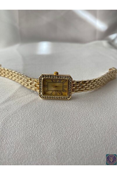 uyguntakıaksesuar ساعة يد نسائية ذهبية بتصميم مستطيل وتفاصيل حجرية – تصميم أن...