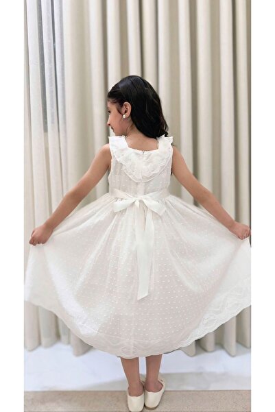 ceneric A girl's dress with prominent polka dot patterns, adorned with lace and decorated with roses.