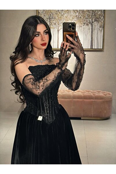 Riva An elegant black dress, with a corset cut and sheer lace sleeves.