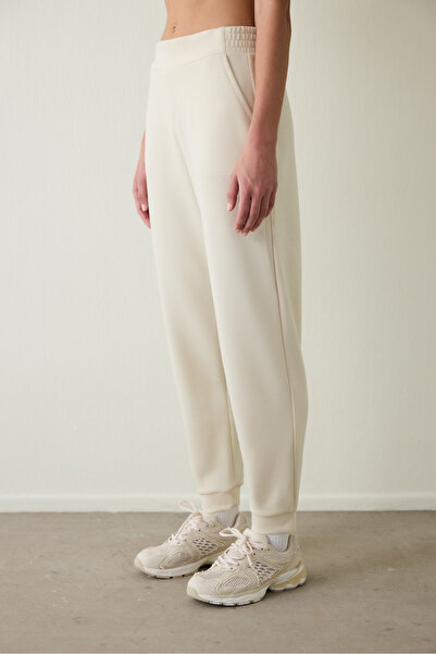 Penti Bézs színű, selymes tapintású, zsebes, fűzős részletekkel ellátott, normál derekú jogger melegítőnadrág