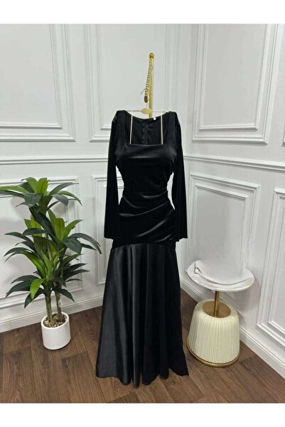 Riva A long, black, velvet, fitted evening dress with a mermaid cut and long sleeves.