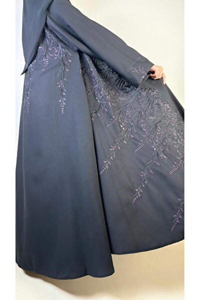 REİNA A full-length flared abaya made of linen crepe with black and mauve embroidery, featuring wide sleeves and a plain headscarf.
