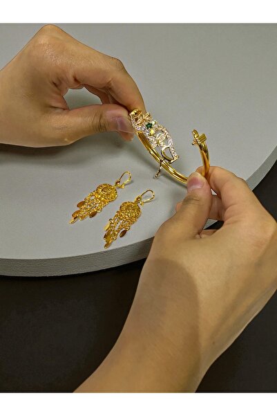 NEW STYLE A gold-look accessory set consisting of a 6cm bracelet and 6.5cm earrings, presented in a suitable gift box.