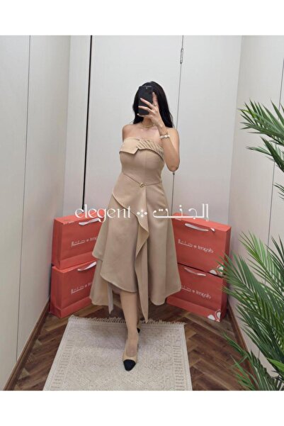 Elegent A soft beige off-the-shoulder dress with elegant pleats and an asymmetrical hemline.