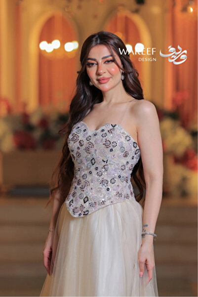 MAC CENTER A long off-white dress with a voluminous tulle skirt and a corset embroidered with stones and crystals.