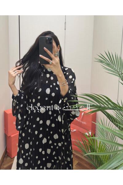 Elegent A black and white polka-dot dress with wide sleeves and modern elegance.