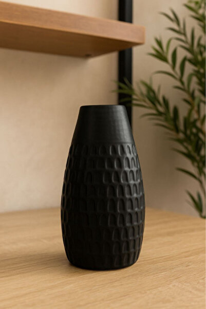 Oss elhetraf A luxurious vase made of black ceramic with a stylish, modern de...