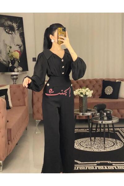 Elegent Elegant black jumpsuit with gold buttons and a puffy-sleeve design ideal for evenings and occasions.
