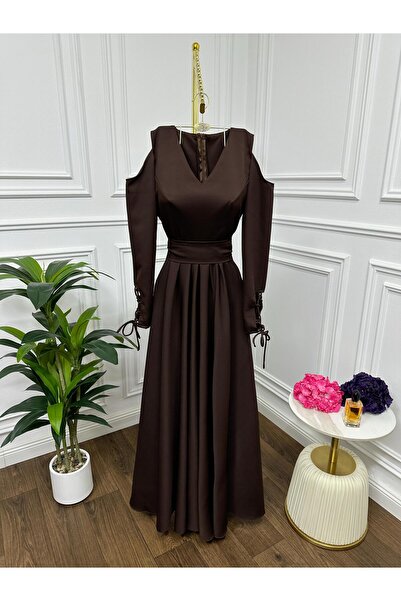 Riva The dress is dark brown and long, with an elegant design.
