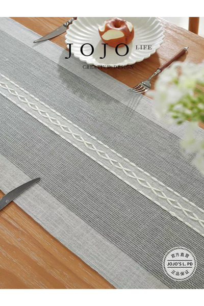 bity thok A luxurious gray dining tablecloth with a modern design and interlocking wicker edges.