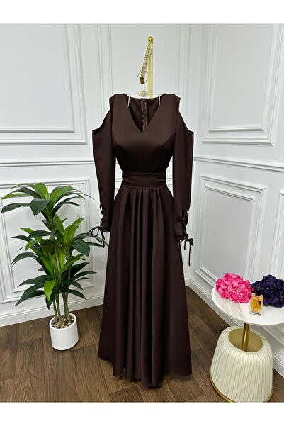 Riva The dress is dark brown and long, with an elegant design.