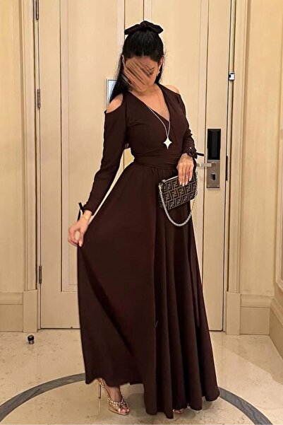 Riva The dress is dark brown and long, with an elegant design.