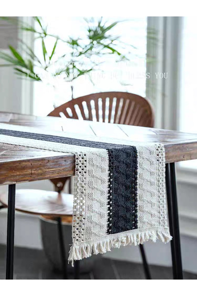 bity thok A luxurious dining tablecloth with a modern design in beige and black colors and elegant scalloped edges.