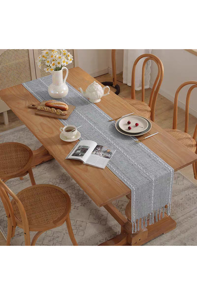 bity thok A luxurious gray dining tablecloth with a modern design and elegant scalloped edges.