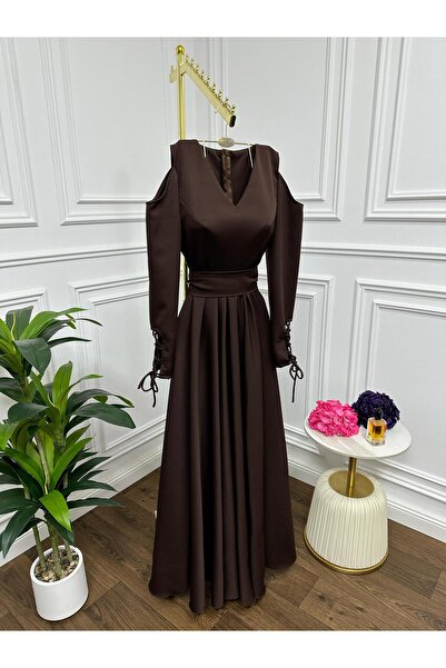 Riva The dress is dark brown and long, with an elegant design.