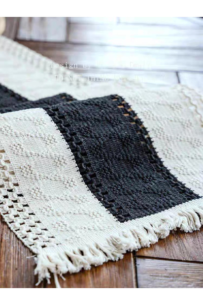 bity thok A luxurious dining tablecloth with a modern design in beige and black colors and elegant scalloped edges.