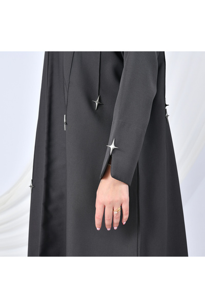 HAWRAA ABAYA A modern design abaya in gray, adorned with gold buttons in the shape of cascading stars, adding a striking touch.