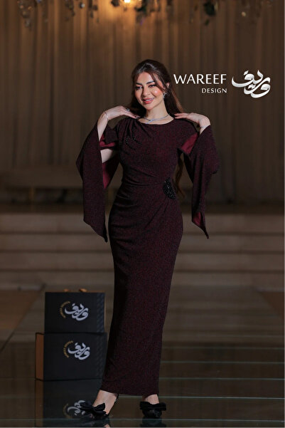 WAREEF FASHION Long burgundy evening gown with a fitted silhouette, wide cape sleeves, luxurious fabric with black sequin embroidery.