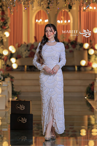 WAREEF FASHION An off-white evening dress with pearl stones and delicate embroidery.