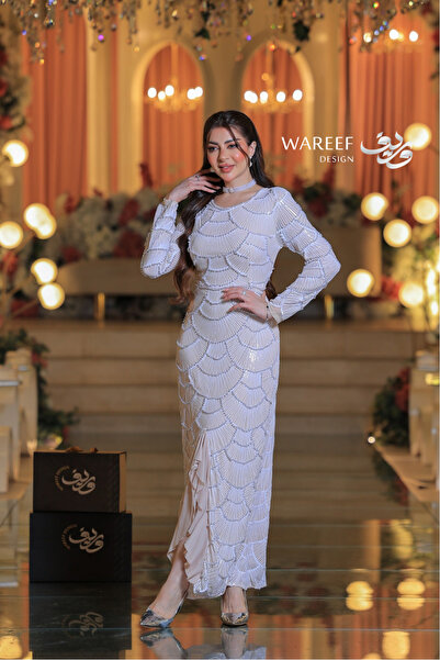 WAREEF FASHION An off-white evening dress with pearl stones and delicate embroidery.