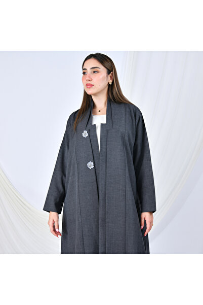 HAWRAA ABAYA A gray abaya with a simple, formal design and a quarter-circle cut, adorned with flower-shaped buttons that add a feminine touch.