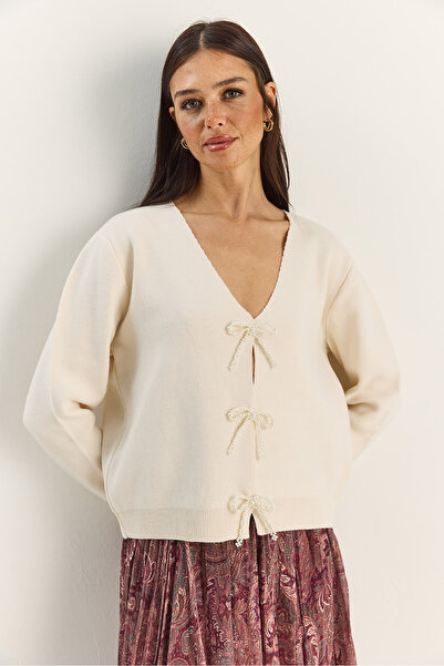 Bianco Lucci Γυναικεία πλεκτή ζακέτα με λαιμόκοψη σε σχήμα V με αξεσουάρ με πέρλες και φιόγκο TH251070 60283885