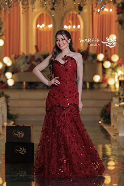 WAREEF FASHION A red evening dress adorned with shimmering embroidery and featuring a plunging neckline.