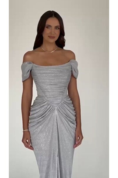 ALFABETA A shimmering evening gown with off-the-shoulder sleeves and an elegant draped silhouette, paired with a shawl.