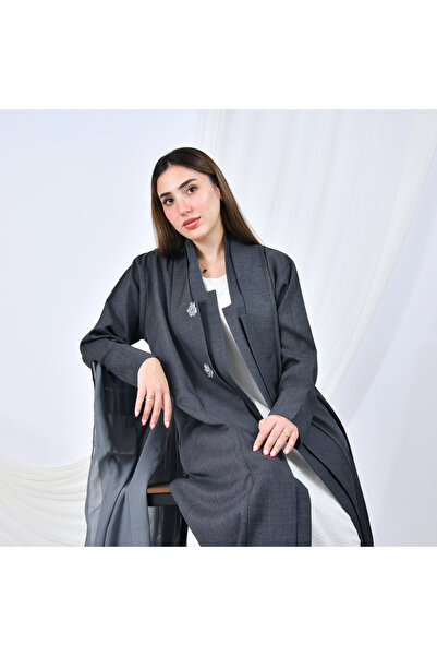 HAWRAA ABAYA A gray abaya with a simple, formal design and a quarter-circle cut, adorned with flower-shaped buttons that add a feminine touch.