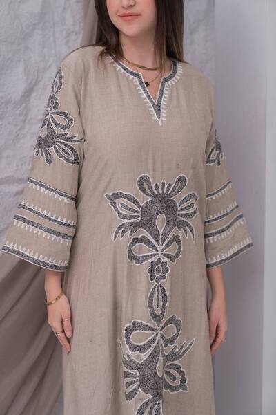 AFandina A linen jalabiya with intricate details that adds a touch of luxury