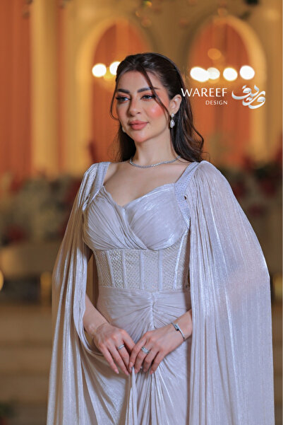 WAREEF FASHION A shimmering off-white evening gown with dramatic sleeves and an embellished crochet detail.