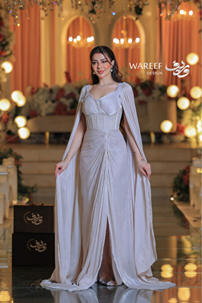 WAREEF FASHION A shimmering off-white evening gown with dramatic sleeves and an embellished crochet detail.