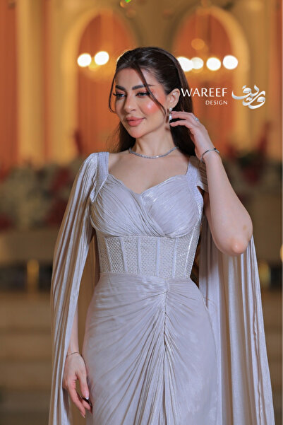 WAREEF FASHION A shimmering off-white evening gown with dramatic sleeves and an embellished crochet detail.