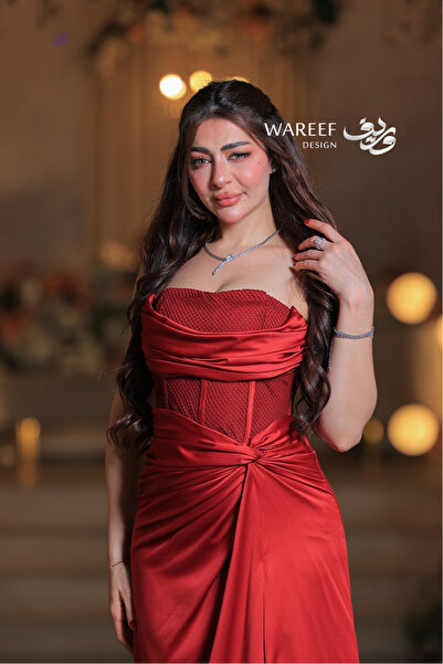 WAREEF FASHION A royal red evening gown with luxurious draping details and an embroidered mesh corset.
