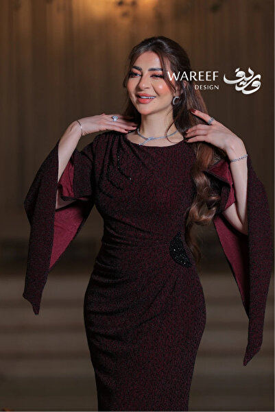 WAREEF FASHION Long burgundy evening gown with a fitted silhouette, wide cape sleeves, luxurious fabric with black sequin embroidery.