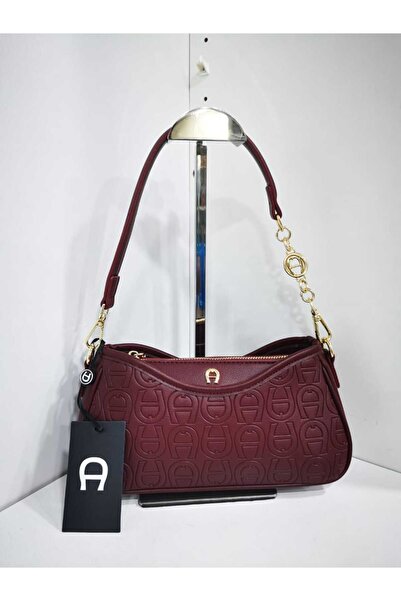 Generic A small burgundy shoulder bag with engraved details and gold accents; an elegant design perfect for special occasions.