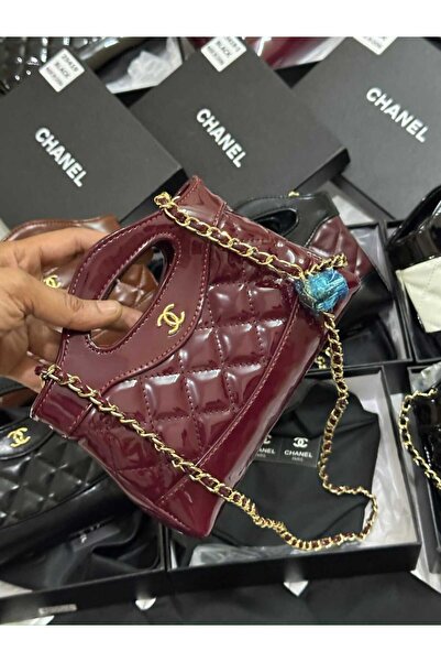 Generic A deep burgundy glossy leather clutch. A gold shoulder chain adds irresistible charm and luxury to all your evenings.