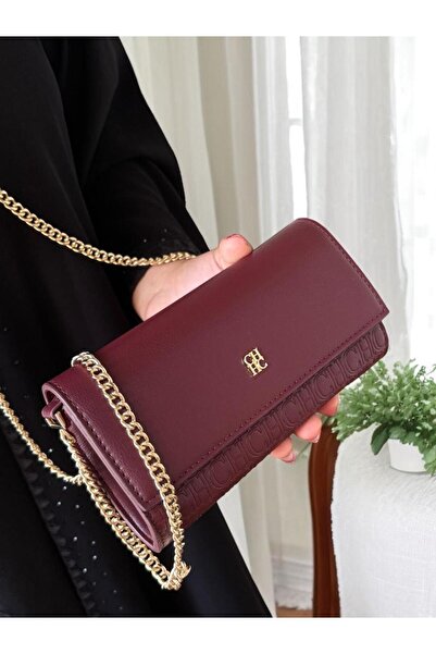 Generic A small burgundy bag with a delicate design and a gold chain that enhances its femininity and luxurious elegance.