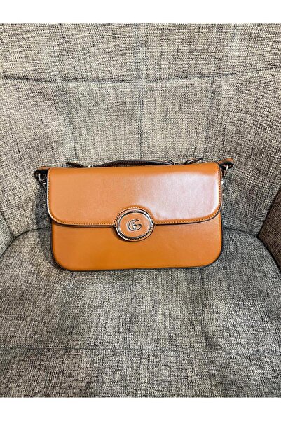 Generic حقيبة كتف مستطيلة بلون الجملي الدافئ، جلد ناعم بشعار دائري فضي. اختيار مثالي لمظهر عملي وأنيق.