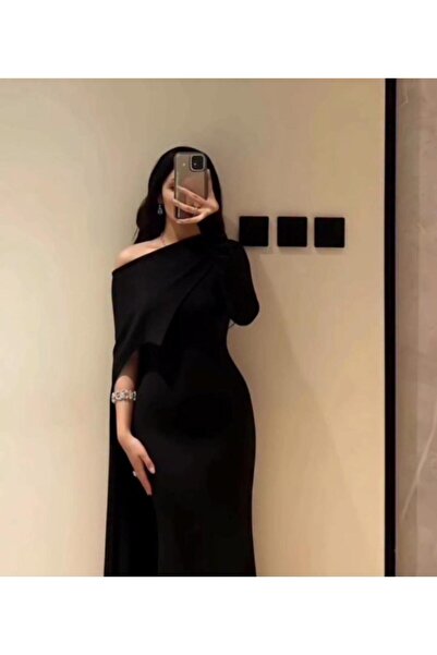 Riva A long black evening dress, with an elegant and distinctive one-shoulder design.