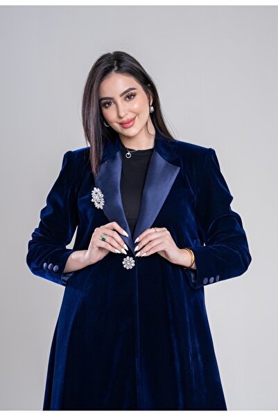 Al Afnan Boutique A winter blazer in a charming navy blue suede velvet fabric with a distinctive taffeta collar and an eye-catching crystal brooch.