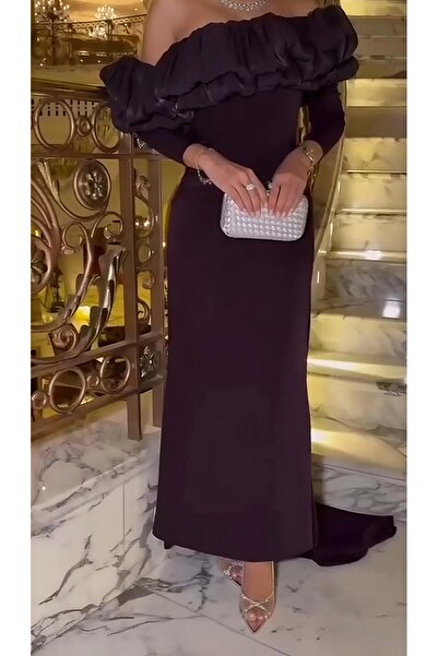 rovan فستان عودي طويل، أكمام ضيقة، أكتاف مكشوفة بكشكشة ضخمة وبارزة مع ذيل خلفي أنيق.