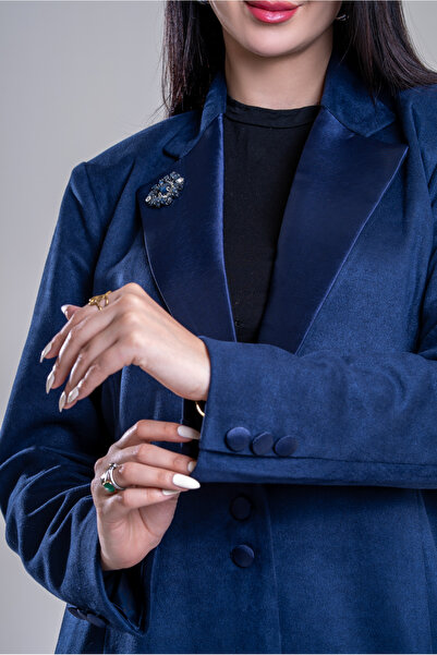 Al Afnan Boutique A navy suede blazer with a distinctive taffeta collar and a navy crystal brooch.