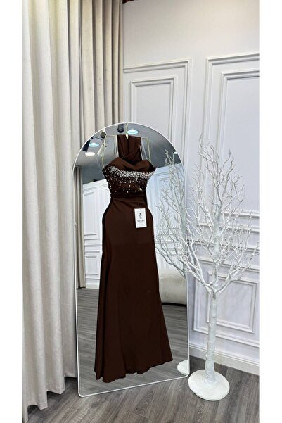 Banan dresses A warm brown evening dress with a flowing design that accentuates the beauty of the figure.