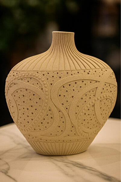 Oss elhetraf A luxurious decorative vase, engraved with a stylish modern design in beige.