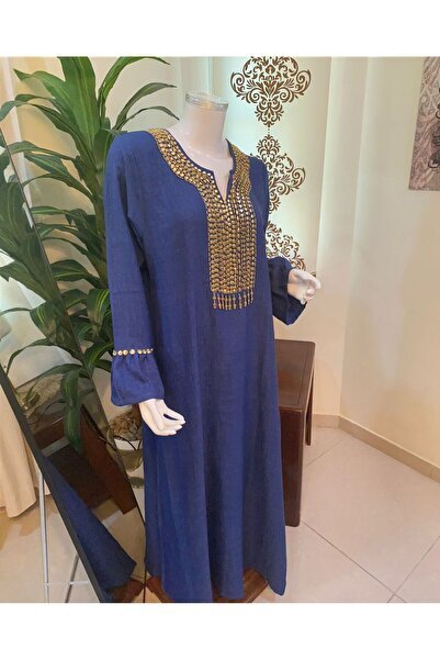 Veil Designer A navy blue jalabiya with gold embroidery on the sleeves and front; hand-embroidered linen fabric.