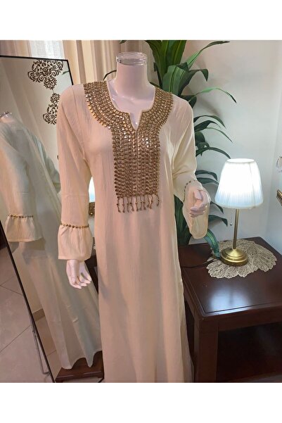 Veil Designer Sugar-colored jalabiya with gold embroidery on the sleeves and front; hand-embroidered linen fabric.